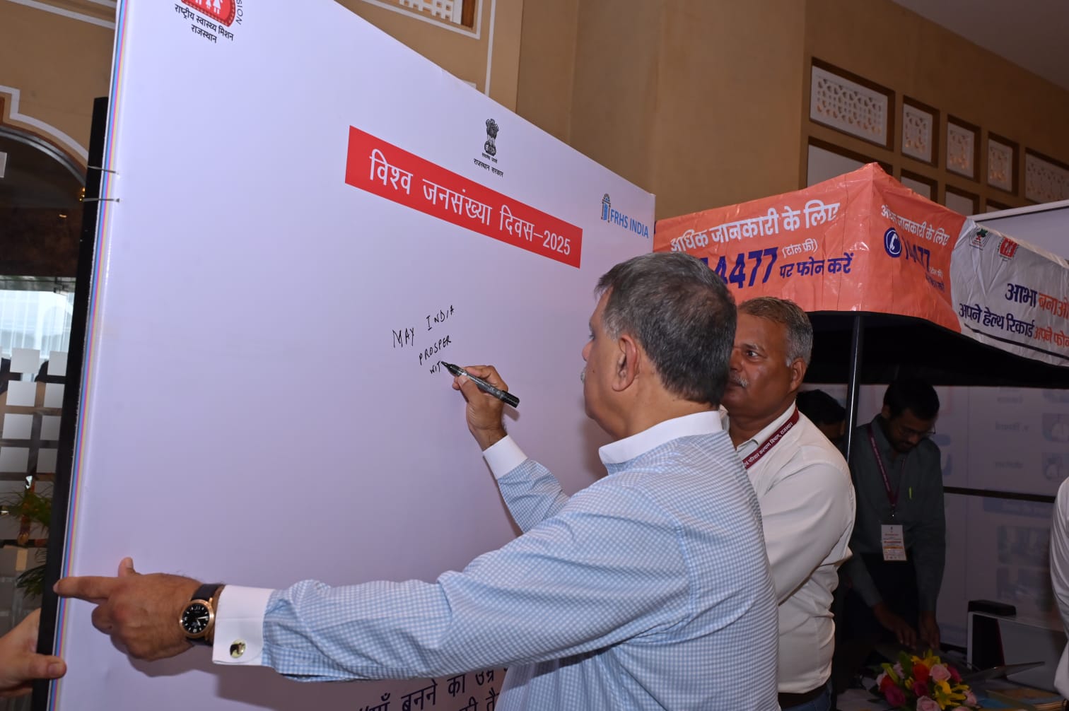 A Rajasthan health official writing a message at the World Population Day 2025 FRHS India stall