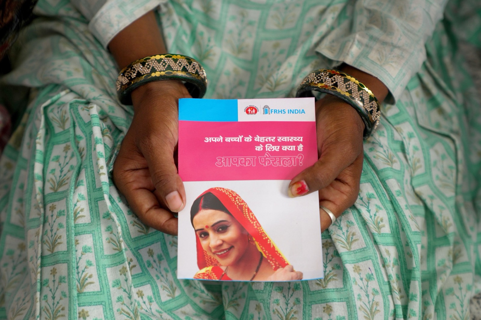 A client holding an FRHS India reproductive health information booklet