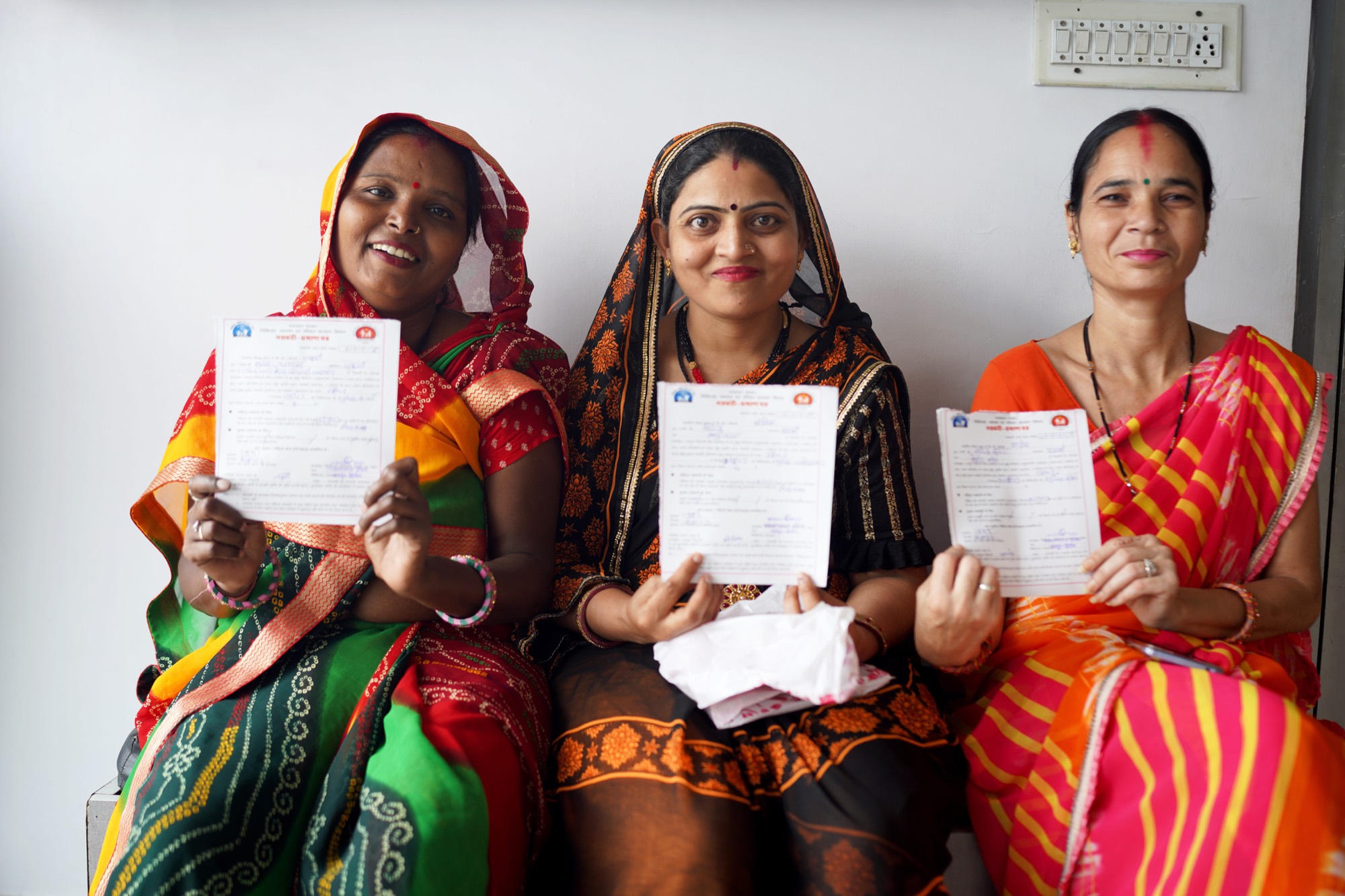 Three FRHS India clients holding their sterilisation certificates