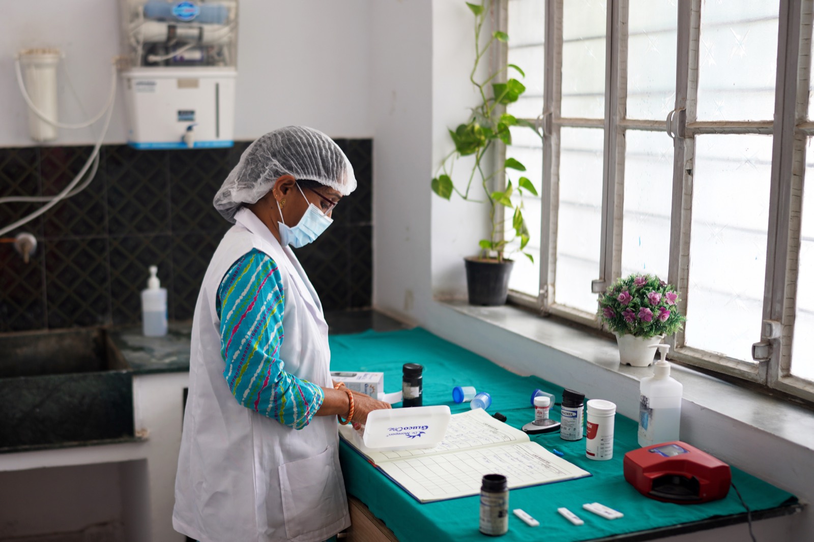 An FRHS India technician carrying out diagnostic tests and recording results in a clinic laboratory